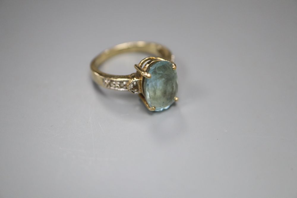 A modern 9ct gold, blue topaz and gem set dress ring, size N, gross 4 grams.